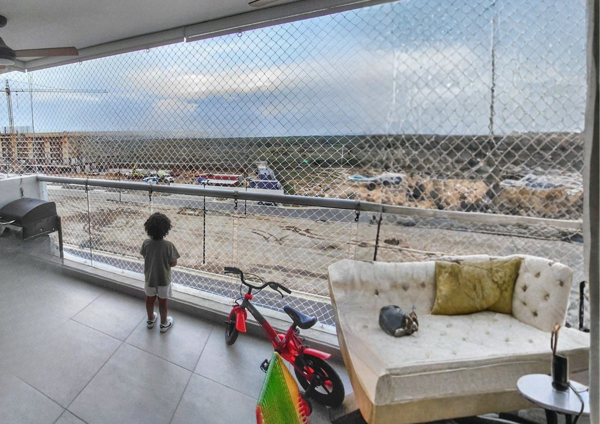 Niño jugando en balcón protegido con malla de seguridad en Barranquilla